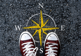 Image of someone standing near a compass
